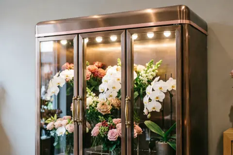 Triple door flower cooler with glass display filled with fresh colorful flowers and LED lighting
